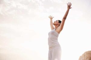 peaceful woman stretching arms towards sky (1)